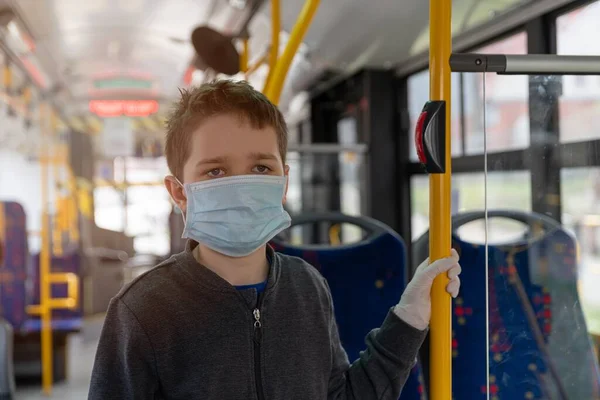 Enfant en masque de protection voyageant en bus public — Photo