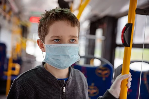 Enfant en masque de protection voyageant en bus public — Photo