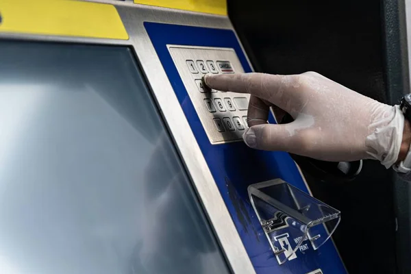 Man using atm money machine in protective gloves
