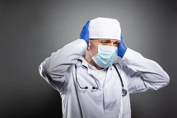Médico cansado con exceso de trabajo en uniforme blanco y máscara médica . —  Fotos de Stock