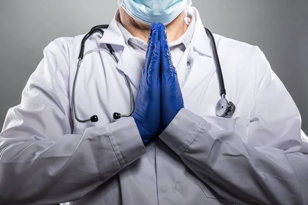 Moe gefrustreerde arts in medisch beschermend masker biddend. — Stockfoto