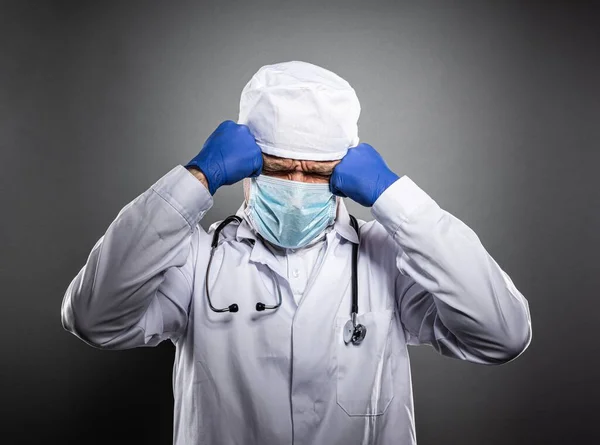 Übermüdeter Arzt in weißer Uniform und medizinischer Maske. — Stockfoto