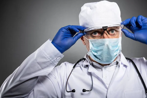 Arzt in medizinischer Schutzmaske mit Schutzbrille zum Augenschutz — Stockfoto