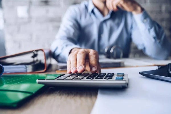 Problemas financeiros durante a crise. Man manager com calculadora contando dinheiro e contas . — Fotografia de Stock