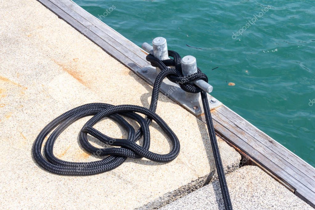 Rope and cleat on dock in marina