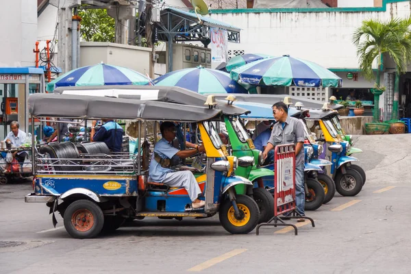 Tuktukar väntar på affärer utanför en färjestation. — Stockfoto