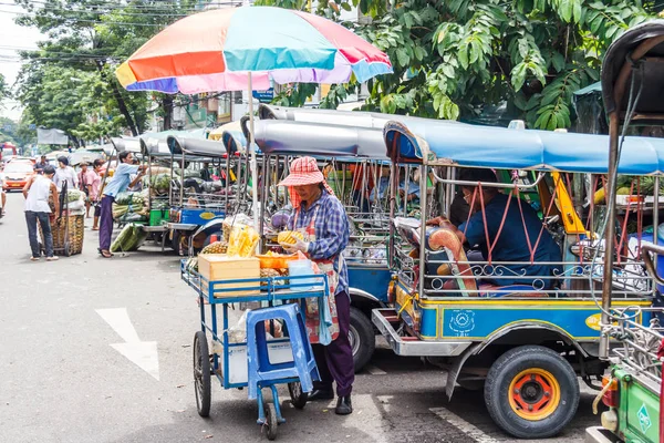 Fruit vendor and tuk tuks — ストック写真