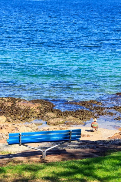 Mann saß am Meer und auf Bank — Stockfoto