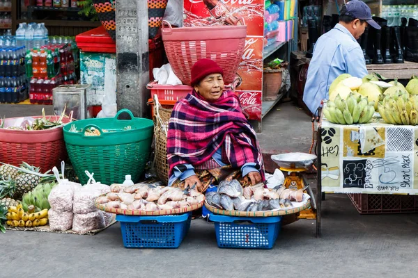 Femme vendant du poisson séché sur le marché . — Photo