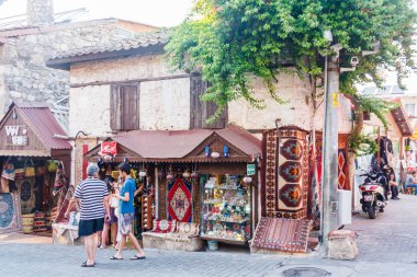 Bir dükkanın önünden geçen turistler