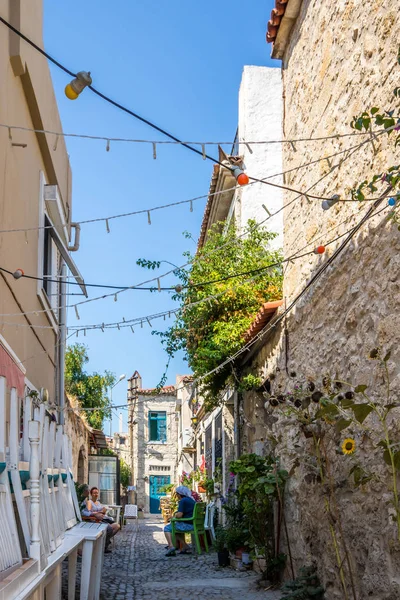 Des gens assis, parlant dans une rue étroite — Photo