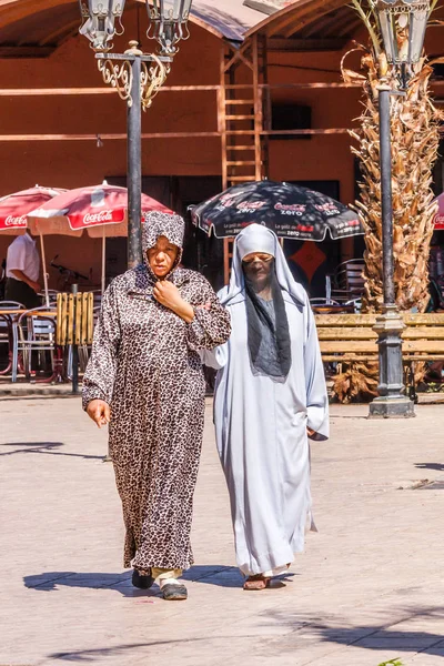 Zwei marokkanische Frauen gehen Arm in Arm. — Stockfoto
