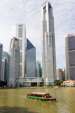 Singapur - 6 Nisan 3017: Singapur nehri üzerinde finans bölgesinin yüksek binaları ile birlikte bumboat. Tekneler turistleri limanda taşıyor..