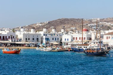 Yunanistan 'ın Mykonos limanında demirlemiş tekneler arkasında Chora kasabası ile birlikte ada popüler bir tatil beldesi..