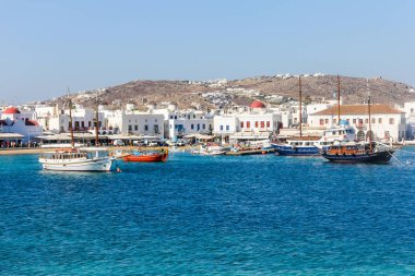 Yunanistan 'ın Mykonos limanında demirlemiş tekneler arkasında Chora kasabası ile birlikte ada popüler bir tatil beldesi..