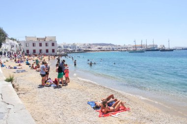 Mykonos, Yunanistan - 23 Temmuz 2016: Chora sahilinde dinlenen turistler. Ada popüler bir tatil beldesi..