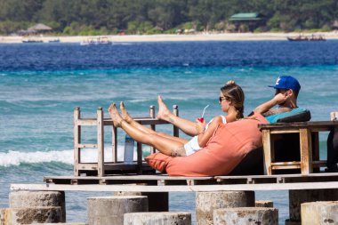Gili Trawangan, Endonezya - 5 Haziran 2017: Genç çift içkiyle dinleniyor. Ada özellikle gençler arasında popülerdir..