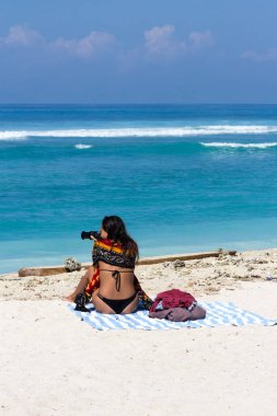 Gili Trawangan, Endonezya - 6 Haziran 2017: Kız Bonkas resifinin üzerinde denize bakıyor. Burası popüler bir sörf sitesi..