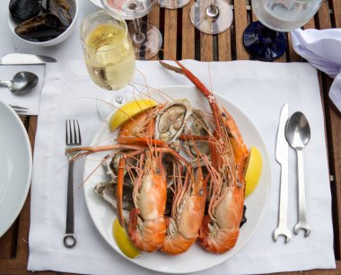 İstiridye ve karides bir bardak beyaz şarapla servis edilir.