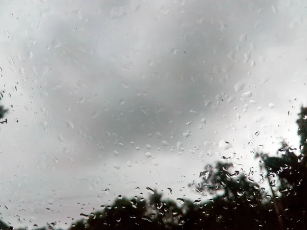 Lluvia sobre vidrio bajo gris nublado — Foto de Stock