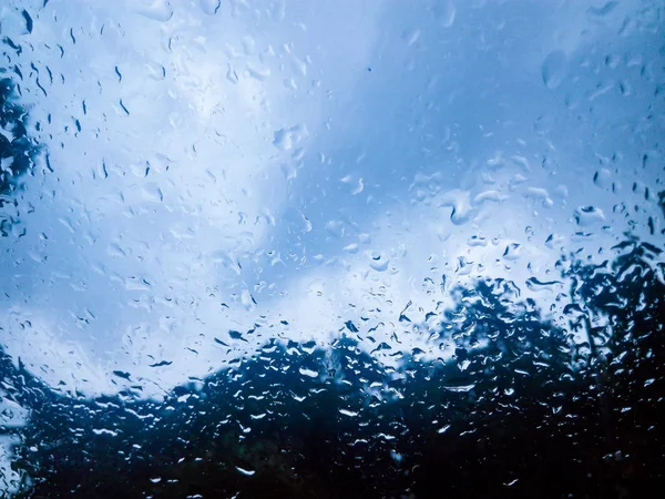 玻璃上的雨和蓝色多云 — 图库照片