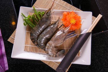 taze karides beyaz tabak ve siyah yemek pişirmek için hazır bac masa