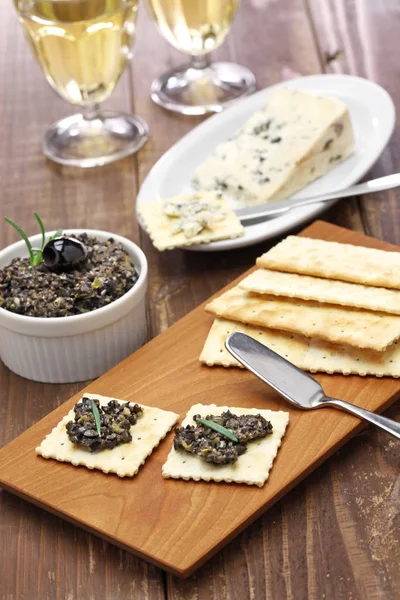 Schwarze Oliventapenade mit Crackern — Stockfoto