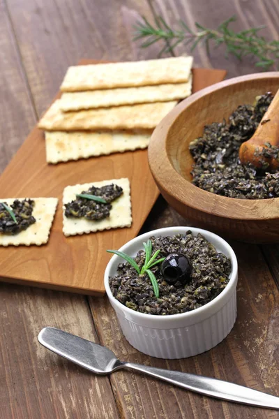 Black olive tapenade with crackers — Stock Photo, Image