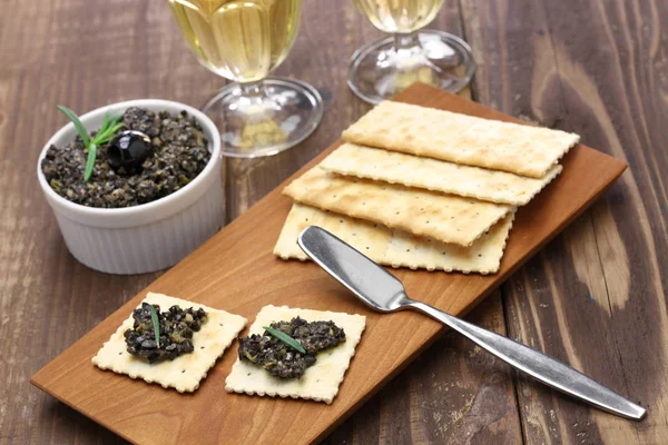 Чорна оливкова тапенада з крекерами — стокове фото