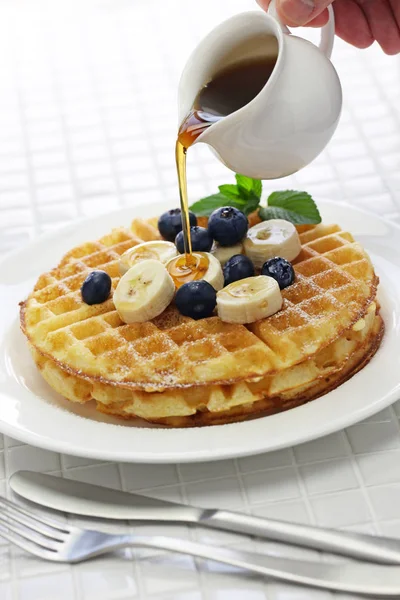 Gieten van ahornsiroop over zelfgemaakte Amerikaanse ronde wafels — Stockfoto