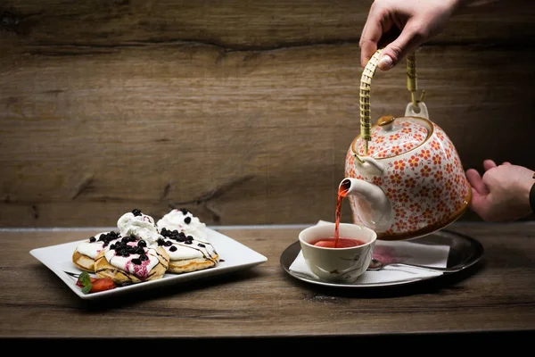 Waffeln und Tee gießen Stockbild