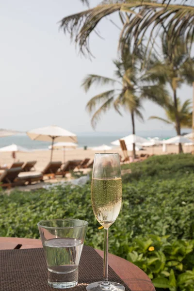 Sklenice Šampaňského Vody Výhledem Tropické Pláže Resort Palmami Lehátky — Stock fotografie