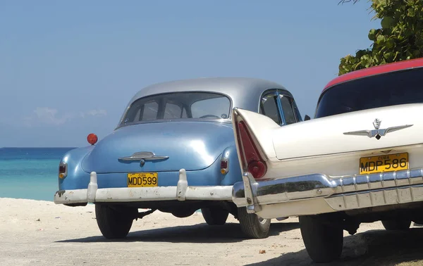 两辆老式的美国汽车在古巴的海滩上艺术 — 图库照片