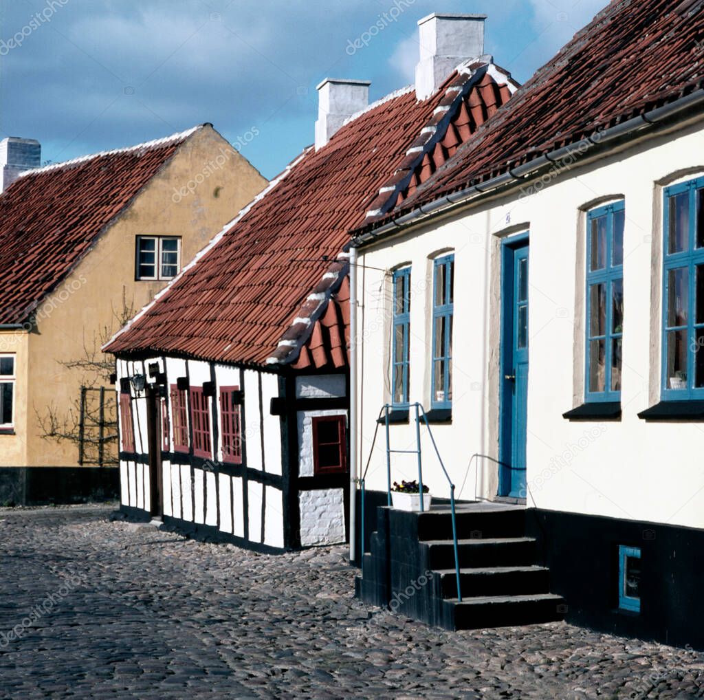 A long cobbled stone street lined with Danish traditional cottages in Ebeltoft, Denmark