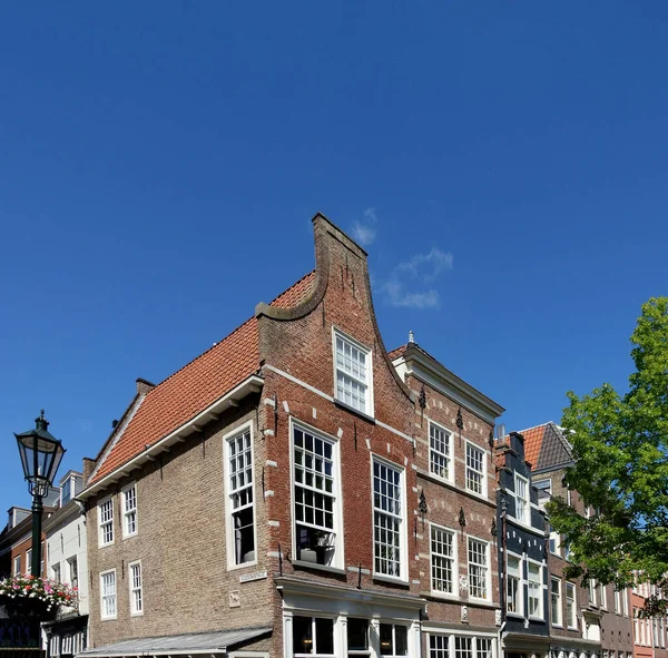 典型的荷兰房子 台阶式的门廊在乌德克斯特拉特 旧教堂街 和荷兰德尔夫特的沃斯特拉特 Voorstraat 的拐角处 蓝蓝的天空映衬着一片蓝天 — 图库照片