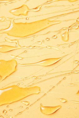 Sarı arkaplanda bal eritme arkaplanı. Metin, damla ve doku için bal yayma yeri.