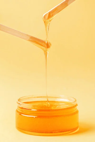 Honig Glas Auf Gelbem Hintergrund Fließt Spachtel Zum Enthaaren Natürliches — Stockfoto