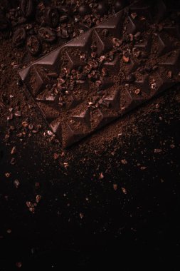 Kakao çekirdekleri, kakao tozu, kakao yağı, çikolata ve çikolata sosu, ahşap bir kasede çikolatalar mesaj atmak için arka planda.