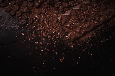 Kakao çekirdekleri, kakao tozu, kakao yağı, çikolata ve çikolata sosu, ahşap bir kasede çikolatalar mesaj atmak için arka planda.