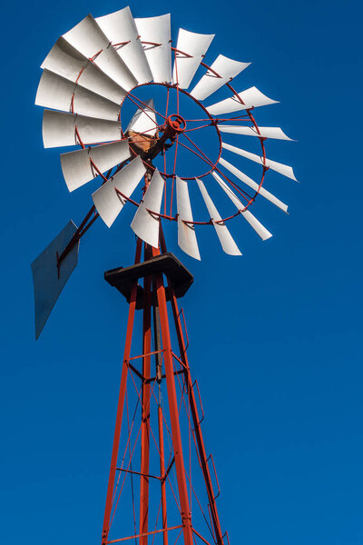 Vintage windmill rotating with blue sky. Energy and climate concept