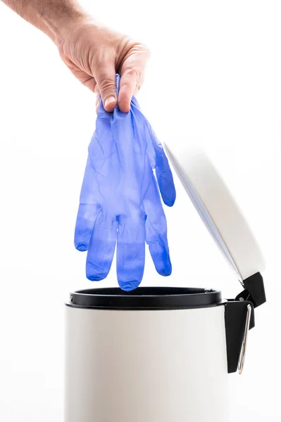 Elindeki koruyucu eldiveni çöp kutusuna at. Coronavirüs kavramının sonu. Covid-19 tedavisi gördü ve karantina sona erdi. Coronavirus atık yönetimi.