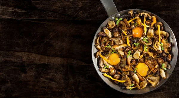 Koekenpan staal met paddestoelen en zacht eigeel. — Stockfoto