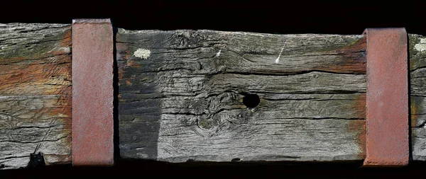 Выветриваемая деревянная балка с ржавой металлической пластиной . — стоковое фото