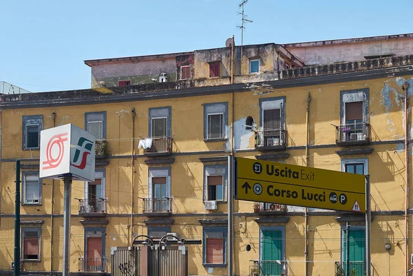 トレニタリアと周遊鉄道の看板の前を持つナポリの建物. — ストック写真
