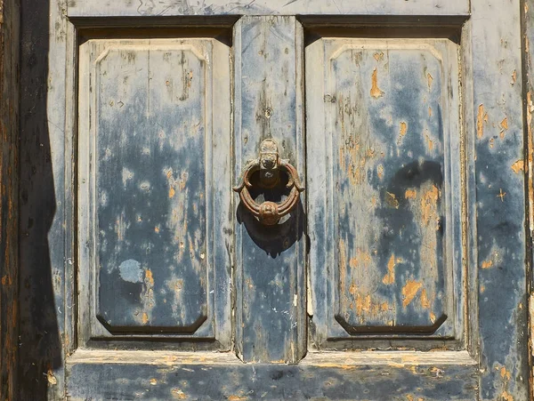 Antika mavi kapı paslı metal halka topuzu arka planı.