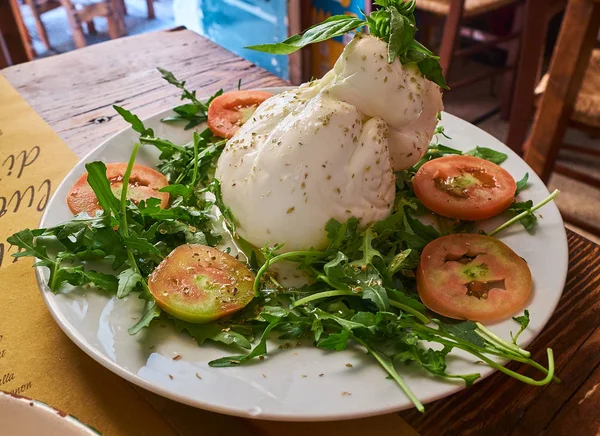 Puglia burrata tecrübeli ve vahşi roket salata ile kazıklı.