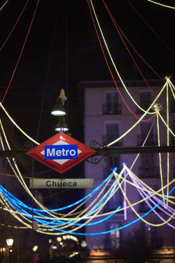 Chueca metro station signboad at night. Madrid, Spain. clipart