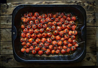 Olgun Kiraz domates dalları metalik fırın çanak içinde kavrulmuş.