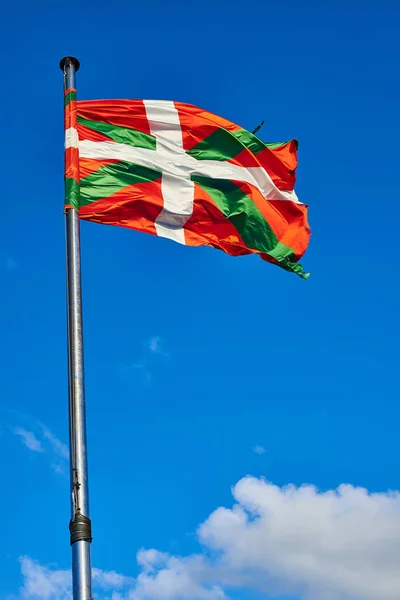 Ikurrina, Drapeau du Pays Basque agitant un ciel bleu . — Photo