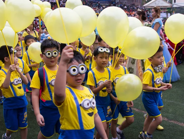 Uczniowie noszą stroje sługusów w Boże Narodzenie Fair 2015 — Zdjęcie stockowe